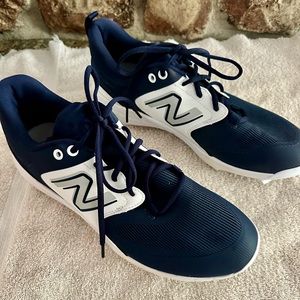 Very gently worn navy blue and white New Balance baseball cleats.